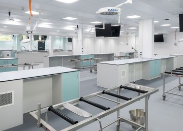 A modern anatomy training laboratory inside the new UEA Edith Cavell Building extension, featuring stainless‑steel clinical tables, ceiling‑mounted screens and specialist teaching equipment created as part of R G Carter’s healthcare and education development.