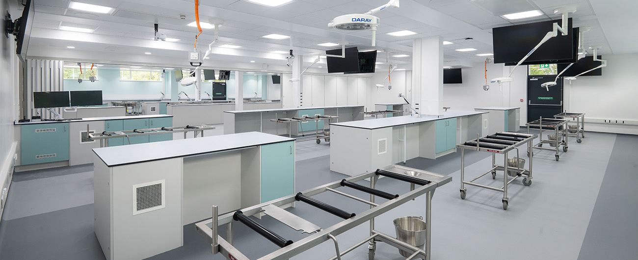 A modern anatomy training laboratory inside the new UEA Edith Cavell Building extension, featuring stainless‑steel clinical tables, ceiling‑mounted screens and specialist teaching equipment created as part of R G Carter’s healthcare and education development.