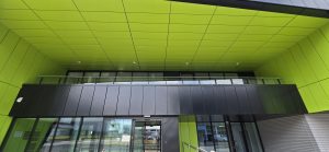 Cantilevered entrance to The Vincent Building at Cranfield University, featuring lime green and black rain-screen cladding.