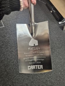 Close-up of an engraved ceremonial spade presented by R G Carter to commemorate the groundbreaking ceremony for Maggie’s Cambridge in October 2026, featuring the Maggie’s and Carter logos.