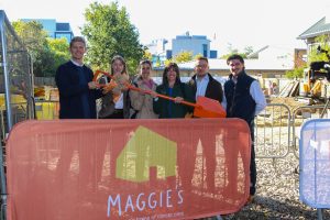 Representatives holding a ceremonial orange shovel during the groundbreaking event.