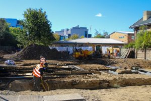 Groundworks in progress with operatives and excavation equipment on site.